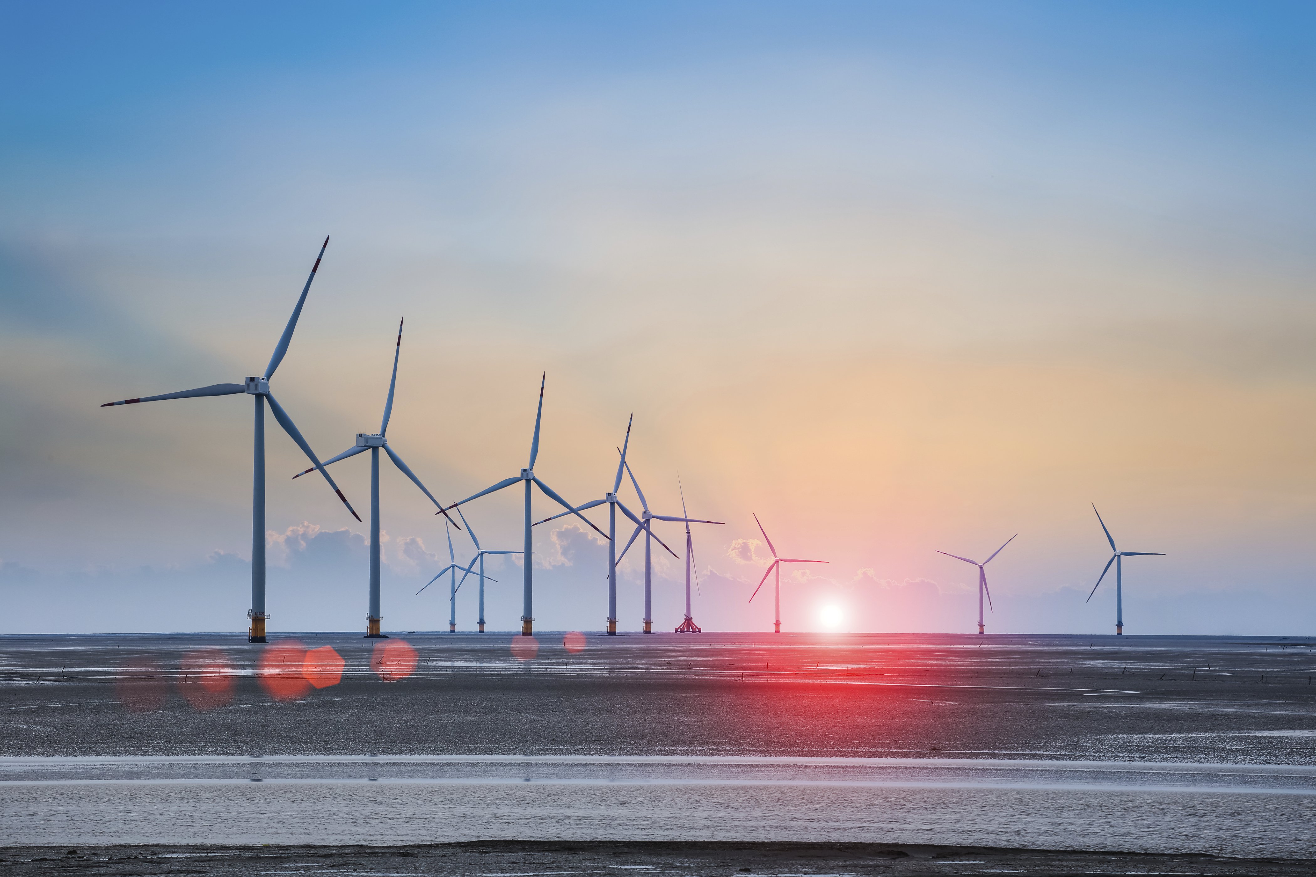 wind turbine farm with rays of light at sunset