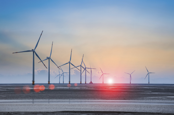 NETWORK DC – Eoliennes-en-mer-Sans-copyright Wind turbine farm with rays of light at sunset